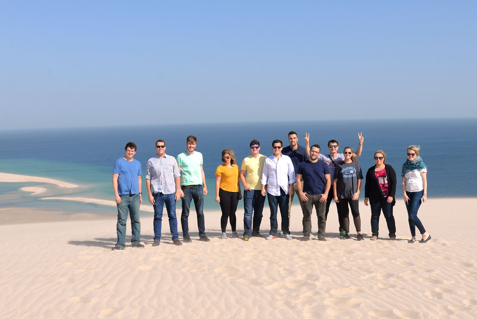 Students stand on one of the towering golden sand dunes in Doha. 